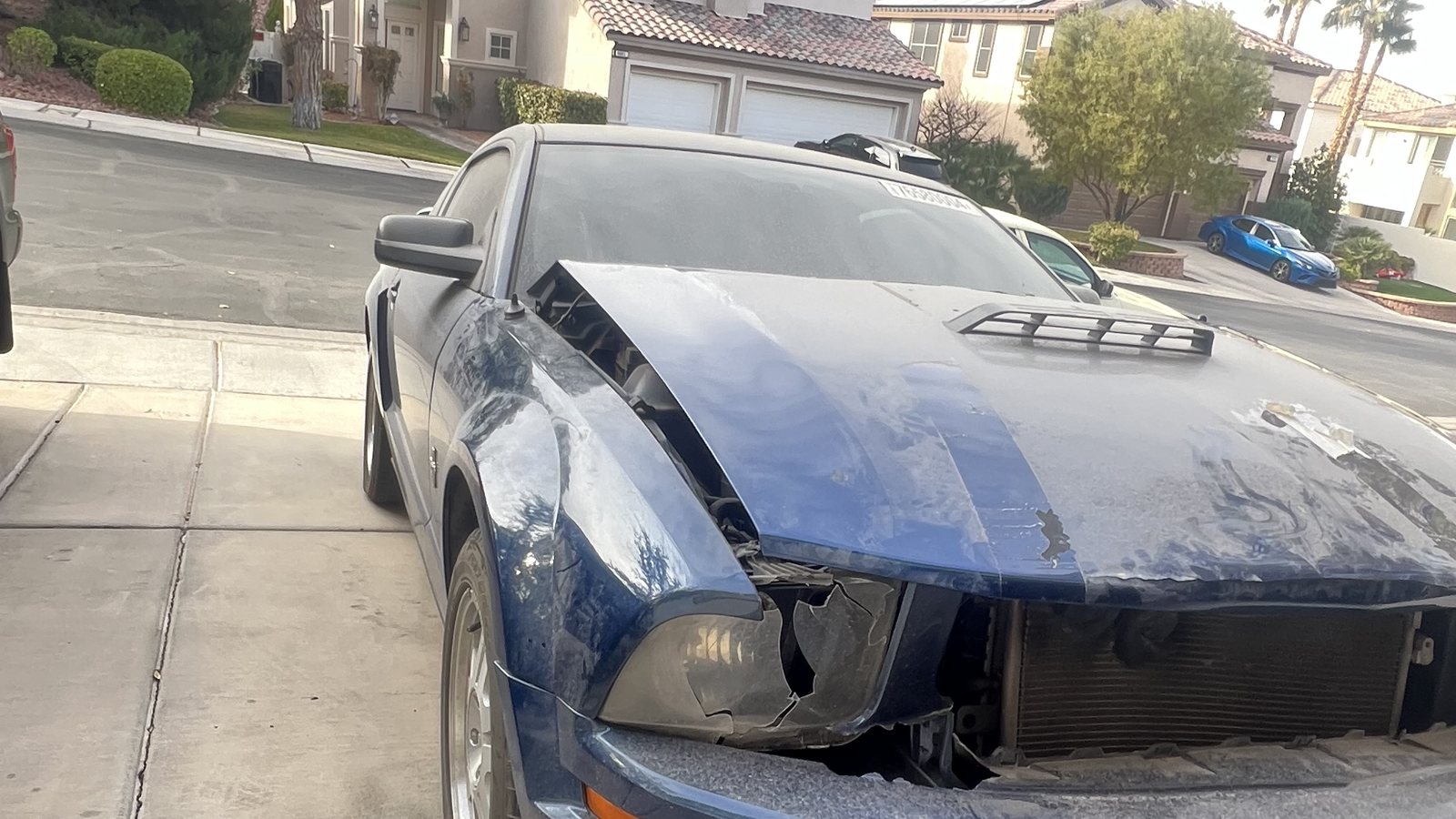 Before: Ford Mustang with front-end collision damage, cracked bumper and damaged hood